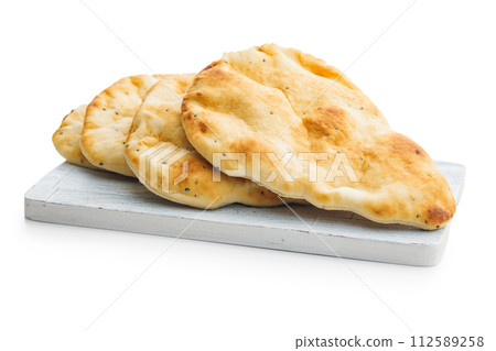 Freshly Baked Naan Bread on cutting board isolated on white background. 112589258