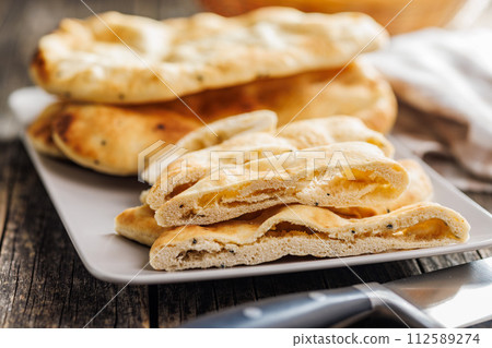 Freshly Baked Naan Bread on plate on wooden table 112589274
