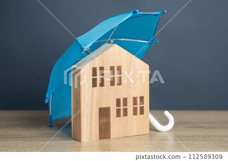 House with blue umbrella. Property insurance. Financial security. Protect investment and be prepared for unforeseen events. Repairs or rebuilding in the event of a covered loss. House with blue umbrella. Property insurance. Financial security. Protect investment and be prepared for unforeseen events. Repairs or rebuilding in the event of a covered loss. 112589309