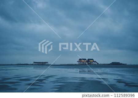 stilt house at sankt peter-ording germany on dark overcast day 112589396