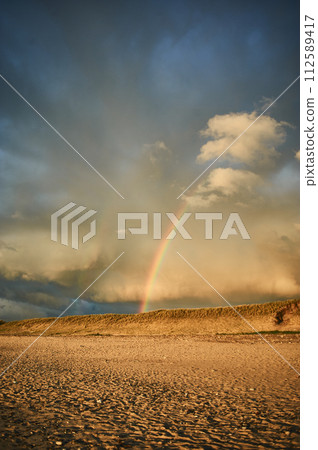 Rainbow over beach in Denmark after rain 112589417