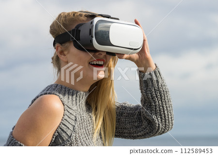 Woman wearing VR outside 112589453