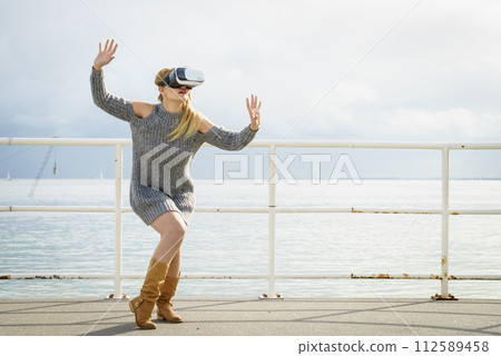 Woman wearing VR outside Woman wearing VR outside 112589458