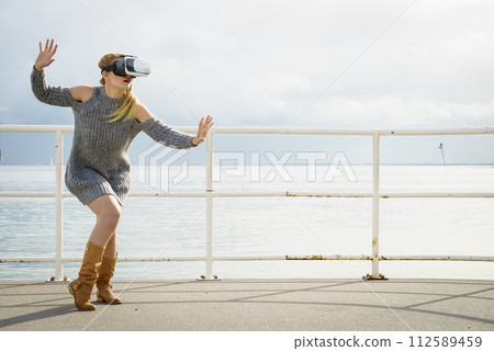 Woman wearing VR outside Woman wearing VR outside 112589459