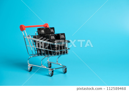 Shopping cart and cubic CO2 carbon dioxide. Greenhouse gas consumption and footprint. Calculate the customers carbon footprint. Be more environmentally friendly. Reduce environmental impact. 112589468