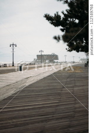 Desolate Boardwalk Leading to a Distant Building in New York Desolate Boardwalk Leading to a Distant Building in New York 112589768