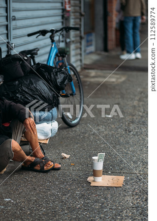 Gritty Scene of New York City Life with Homeless Person Seated by Bike 112589774
