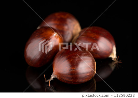 Chestnuts on a black reflective background Chestnuts on a black reflective background 112590228