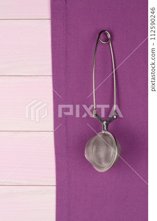 Kitchenware on purple towel 112590246