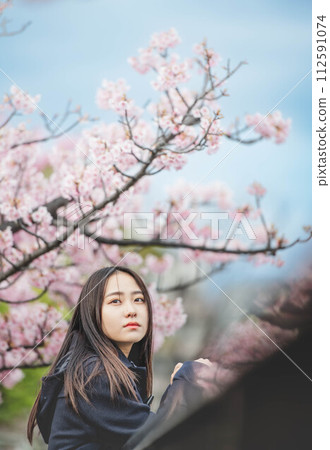 High school girl putting her hand on the railing under the cherry blossoms High school girl putting her hand on the railing under the cherry blossoms 112591074