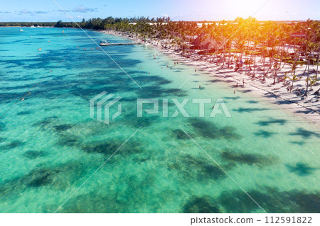 Sunset or sunrise on tropical beach with resorts, palm trees and caribbean sea. Dominican Republic. Aerial view 112591822