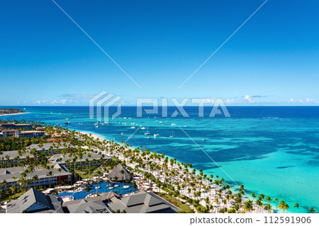 Tropical beach with resorts, palm trees and caribbean sea. Dominican Republic. Aerial view Tropical beach with resorts, palm trees and caribbean sea. Dominican Republic. Aerial view 112591906