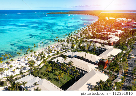 Sunset or sunrise on tropical beach with resorts, palm trees and caribbean sea. Dominican Republic. Aerial view 112591910