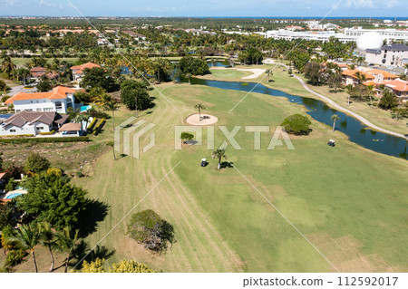 Golf club field with cart and playing golfers. Aerial view Golf club field with cart and playing golfers. Aerial view 112592017