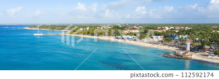 Dominicus beach at Bayahibe with Caribbean sea sandy seashore, lighthouse and pier. Aerial view. Long banner Dominicus beach at Bayahibe with Caribbean sea sandy seashore, lighthouse and pier. Aerial view. Long banner 112592174