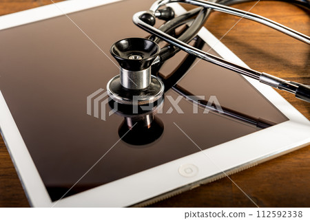 medical stethoscope and tablet on brown wooden background. Health care concept. phonendoscope. 112592338