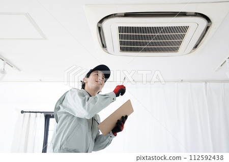 一名男工人正在檢查天花板上的空調 112592438