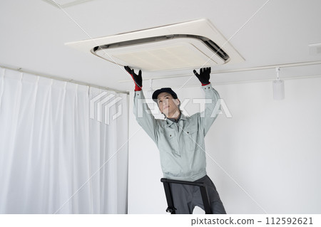一名男工人正在檢查天花板上的空調 112592621