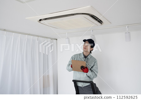 一名男工人正在檢查天花板上的空調 112592625