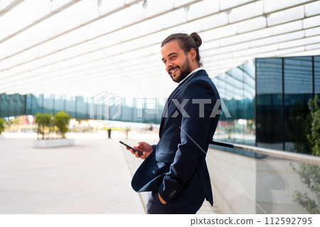 Businessman standing outdoor use smartphone 112592795