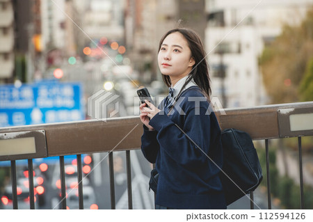 High school girls leaving school and evening cityscape 112594126