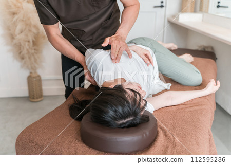 A woman who goes to a chiropractic clinic/osteopathic clinic/massage and a chiropractor/therapist (clavicle/clavicle massage/clavicle lymph node) 112595286
