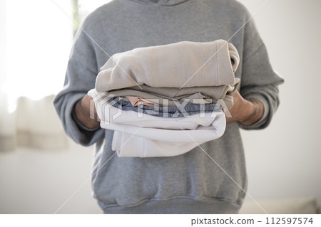 Close-up of faceless man doing housework folding laundry 112597574