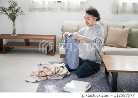 亞洲(日本)男人在客廳做家事,摺衣服 亞洲(日本)男人在客廳做家事,摺衣服 112597577