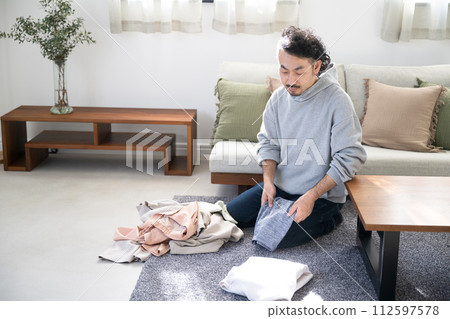 亞洲(日本)男人在客廳做家事,摺衣服 亞洲(日本)男人在客廳做家事,摺衣服 112597578