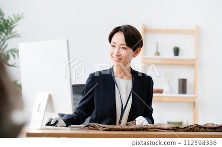 A clerk appraising a kimono 112598336