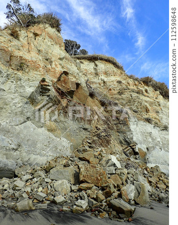 Collapsed rock wall on a sandy beach Collapsed rock wall on a sandy beach 112598648