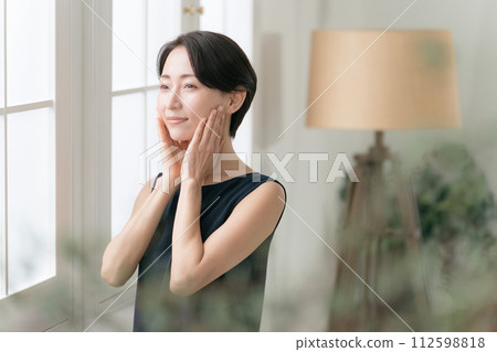 A woman in her 30s feels the moisture in her skin 112598818