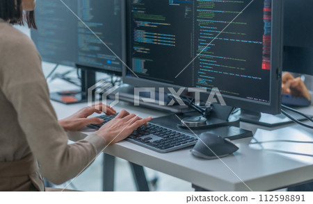 close up hand of Asian prompt engineer developer coding app with software data sitting in front of computer monitor at office 112598891