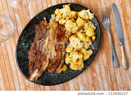 Lunch for restaurant guest - fried fatty and juicy lamb and vegetable side dish of cauliflower Lunch for restaurant guest - fried fatty and juicy lamb and vegetable side dish of cauliflower 112600227