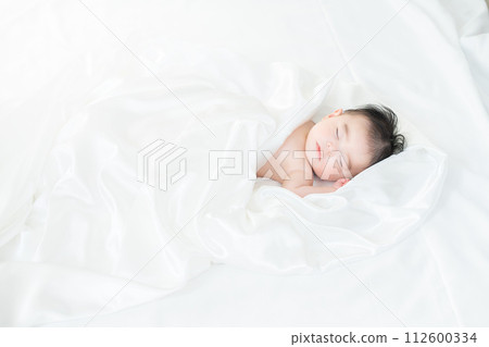 4 month old boy sleeping wrapped in sheets 112600334