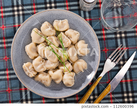 Pelmeni with meat served in broth with green onions Pelmeni with meat served in broth with green onions 112600396