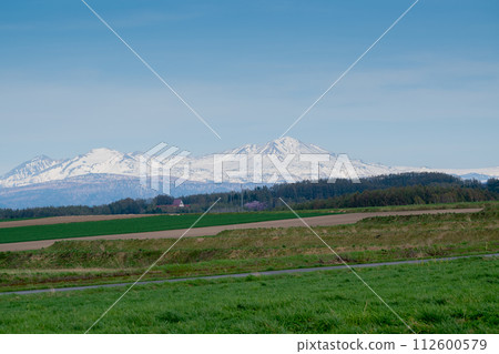Spring fields and mountains with remaining snow Daisetsuzan Spring fields and mountains with remaining snow Daisetsuzan 112600579