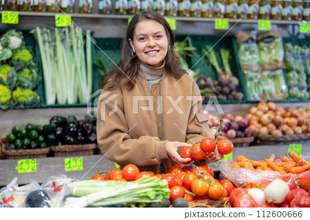 Young girl buying tomatoes in grocery store 112600666