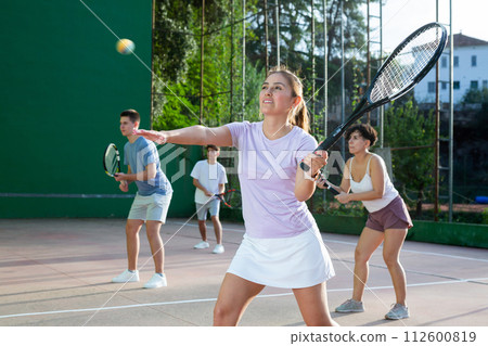 Expressive resolved fit girl playing frontenis ball friendly match on court 112600819