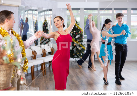 Woman in red enjoying passionate salsa with colleague at corporate Christmas party Woman in red enjoying passionate salsa with colleague at corporate Christmas party 112601084