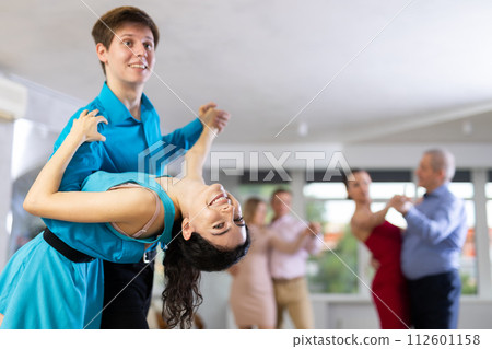 Young couple performing dip move while dancing in salsa class 112601158