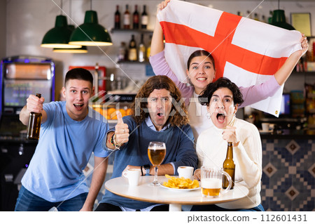Glad males and females with England flag clinking glasses with beer on party 112601431