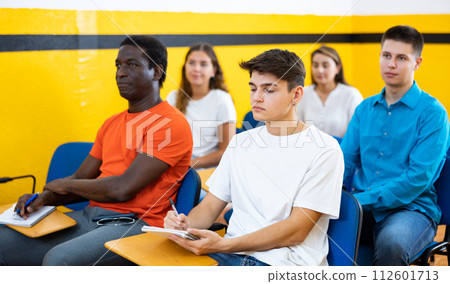 Women and men attending lecture in taxi training school 112601713