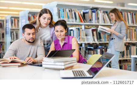 Female and male colleagues working together in public library 112601717