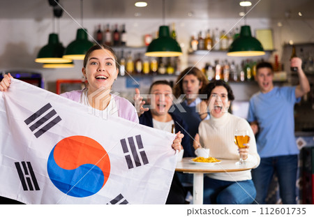 Group of happy friends with flag of South Korea celebrating victory of their favorite team in beer bar 112601735
