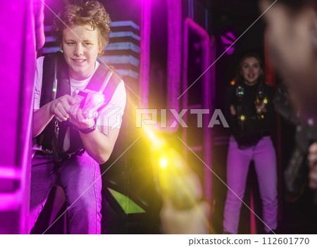 Boy running and dodging while playing lasertag Boy running and dodging while playing lasertag 112601770
