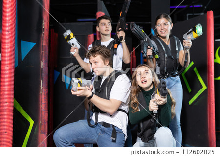 Four people with lasertag guns squatting in arena 112602025