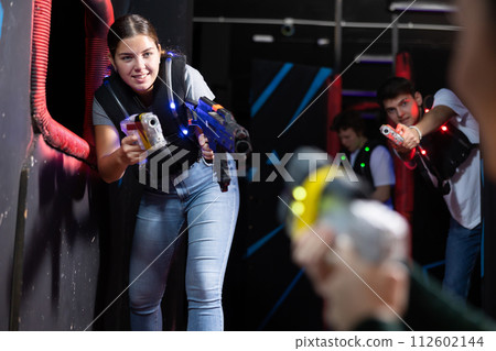 Young woman playing lasertag in arena 112602144