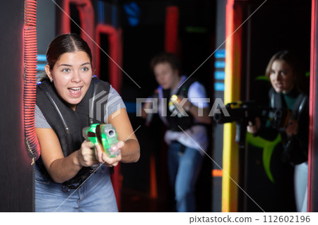 Young lady having fun playing lasertag in arena 112602196