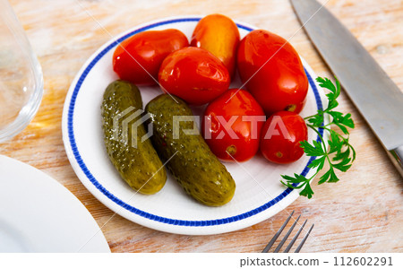 Homemade marinated tomatoes and cucumbers on plate 112602291